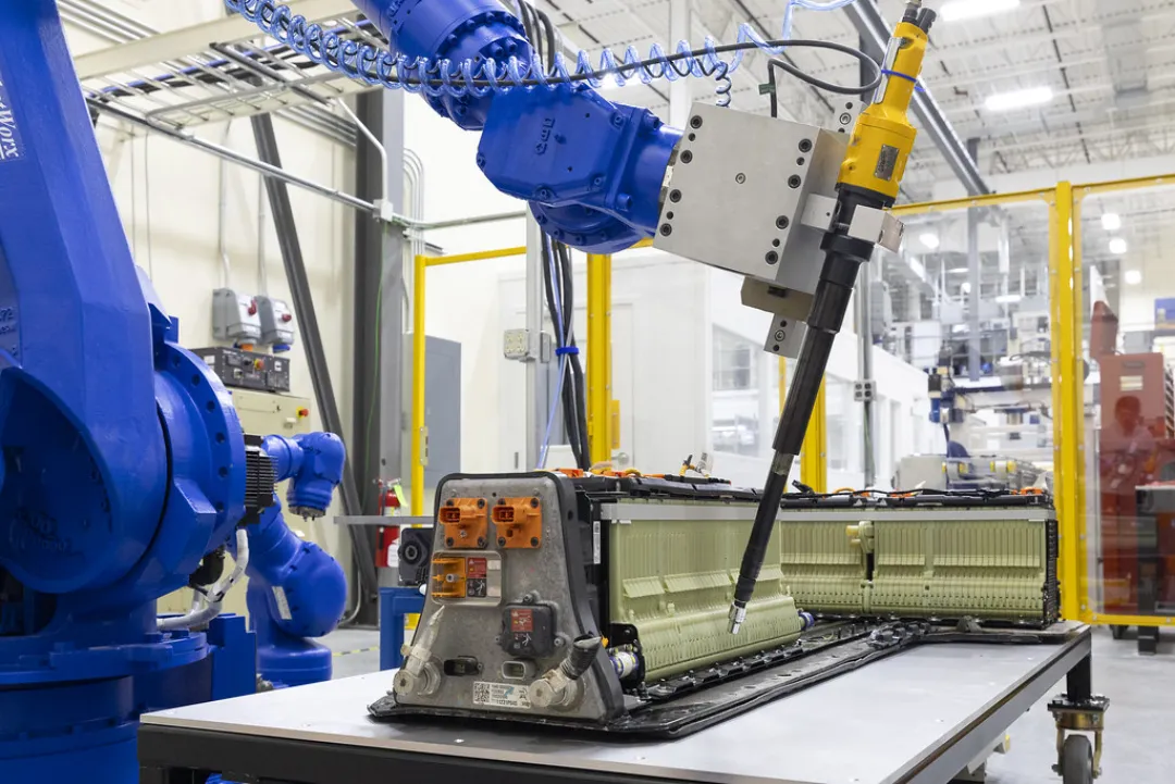 A robot arm taking apart an electric vehicle battery pack on a bench at Oak Ridge National Laboratory.